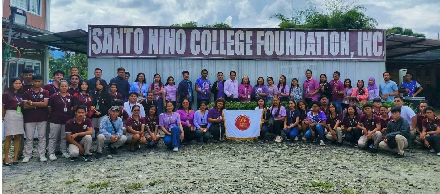 SNCFI students, faculty and staff gathered on campus under the school's sign